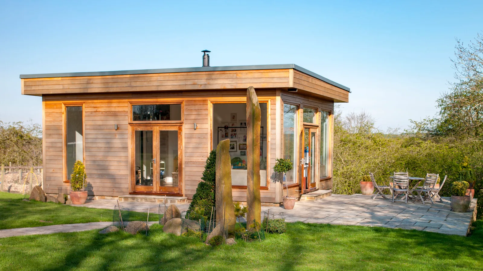 A timber clad garden office and studio in a rural garden, the kind of building that needs its own electrical supply run from the house