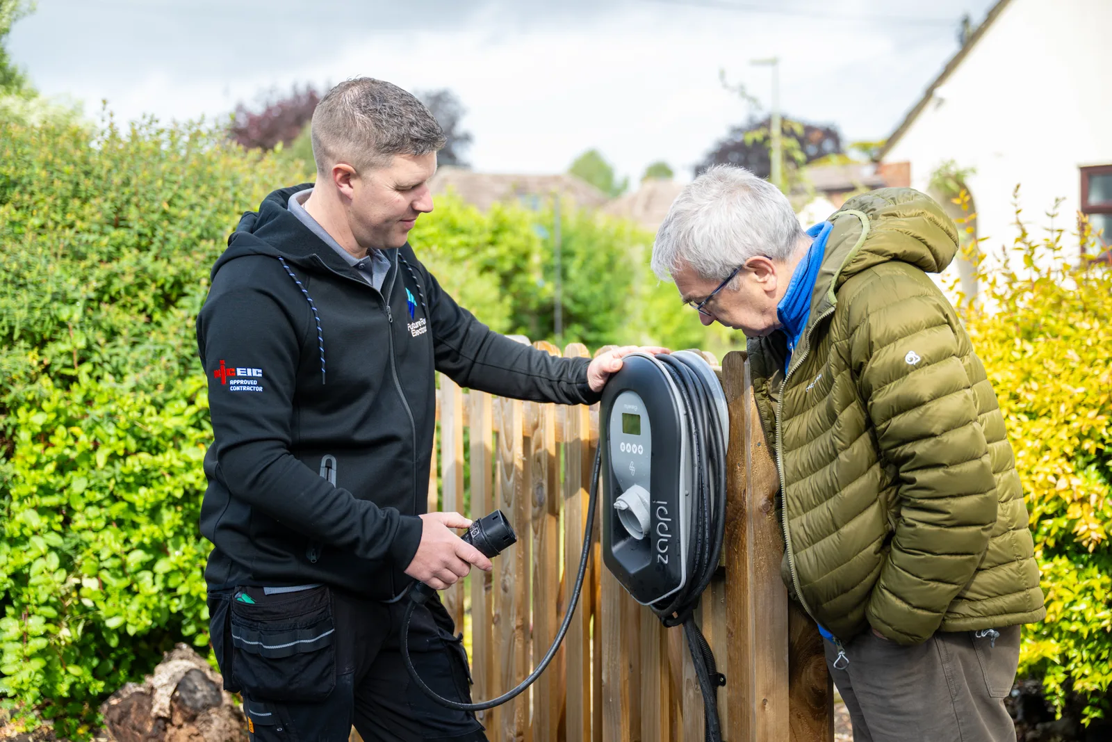 Future Flow electrician showing the finished Myenergi Zappi charge point to the customer at their Ringwood home